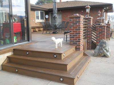 Composite Deck with Brick Posts, Iron Rail & Accent Lighting by Deck Works in Colorado Springs