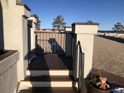 Stucco Deck with Stamped Concrete, Stairway, Lighting & Iron Rail built by Deck Works in Colorado Springs