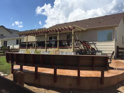 Deck with Pergola, Stairway, Bench & Stamped Concrete Patio by Deck Works in Colorado Springs