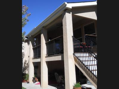 Covered Stucco Deck with Iron Rail, Accent Lighting & Stairway built by Deck Works in Colorado Springs