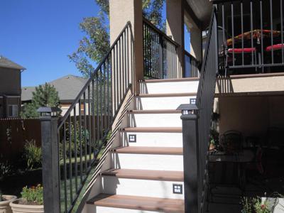 Covered Stucco Deck with Iron Rail, Accent Lighting & Stairway built by Deck Works in Colorado Springs
