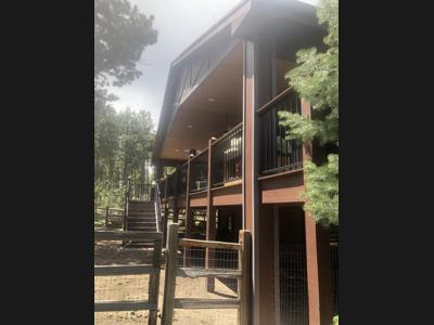 Covered Wrap-Around Deck with Iron Rails, Stairways and Accent Lighting built by Deck Works in Colorado Springs
