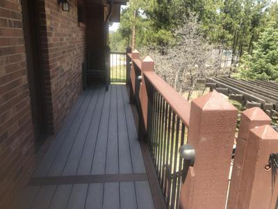 Covered Wrap-Around Deck with Iron Rails, Stairways and Accent Lighting built by Deck Works in Colorado Springs