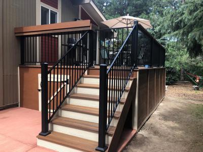 Composite Deck with Stairway, Deck Skirt, Iron Rail, Shelf, Gate and Concrete Slab built by Deck Works in Colorado Springs