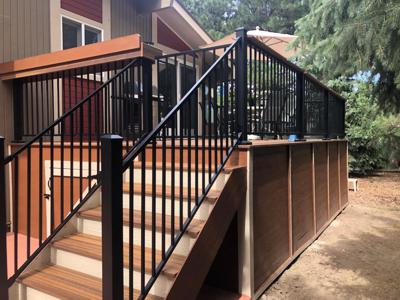 Composite Deck with Stairway, Deck Skirt, Iron Rail, Shelf, Gate and Concrete Slab built by Deck Works in Colorado Springs