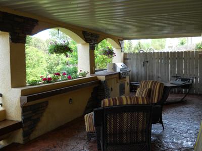 Covered Stucco Deck with Outdoor Living and Stamped Concrete by Deck Works in Colorado Springs