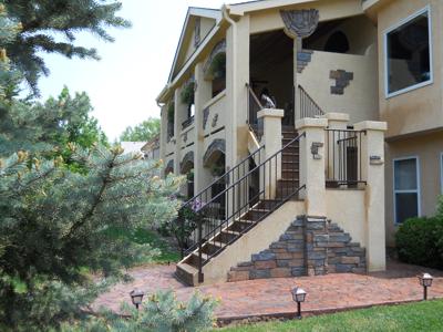 Covered Stucco Deck with Outdoor Living and Stamped Concrete by Deck Works in Colorado Springs