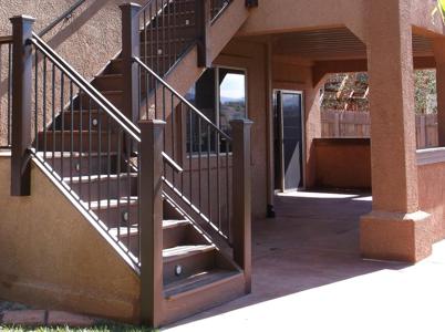 Stucco Deck with Stairway, Lighting, Flowerboxes, Iron Rail & Dry Below System by Deck Works in Colorado Springs