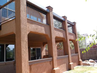 Stucco Deck with Stairway, Lighting, Flowerboxes, Iron Rail & Dry Below System by Deck Works in Colorado Springs