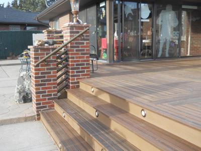 Composite Deck with Brick Posts, Iron Rail & Accent Lighting by Deck Works in Colorado Springs