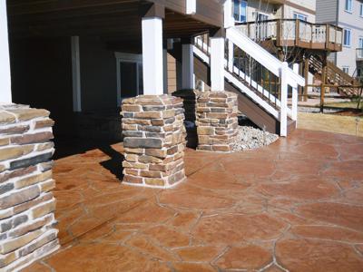 Stone Deck with Stairway, Decorative Concrete Patio, Custom Rail & Accent Lighting built by Deck Works in Colorado Springs